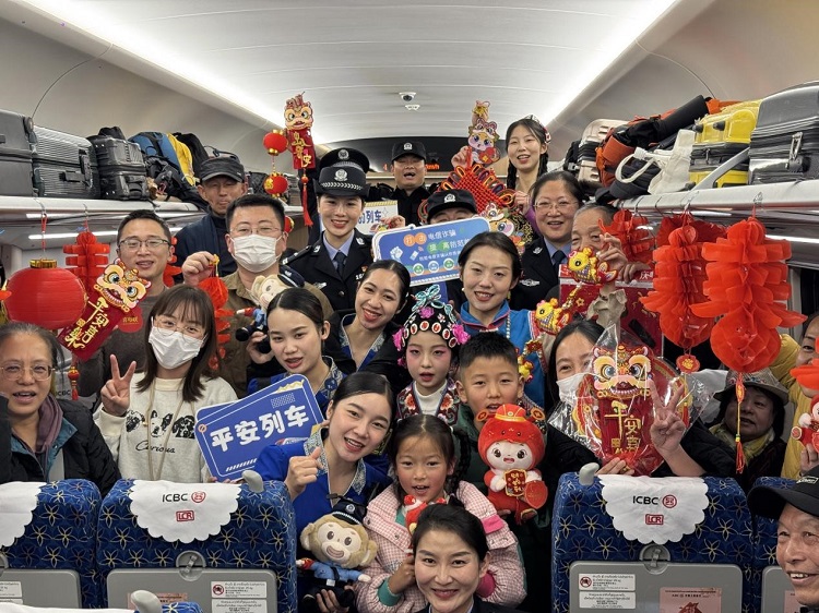 春節(jié)期間，在中老鐵路磨萬（磨丁—萬象）段，鐵路客運員工與乘客合影留念。李加勇攝