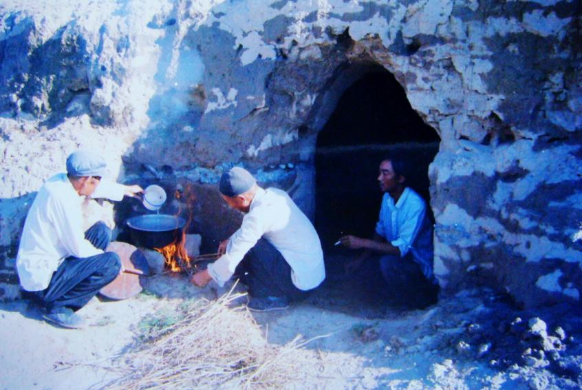 1983年，“六老漢”一代治沙人在“地窩子”生活做飯。新華社發(fā)（八步沙林場供圖）