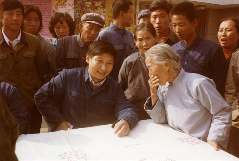 1983年，時(shí)任河北正定縣委書記的習(xí)近平（前排居中），臨時(shí)在大街上擺桌子聽取老百姓意見。