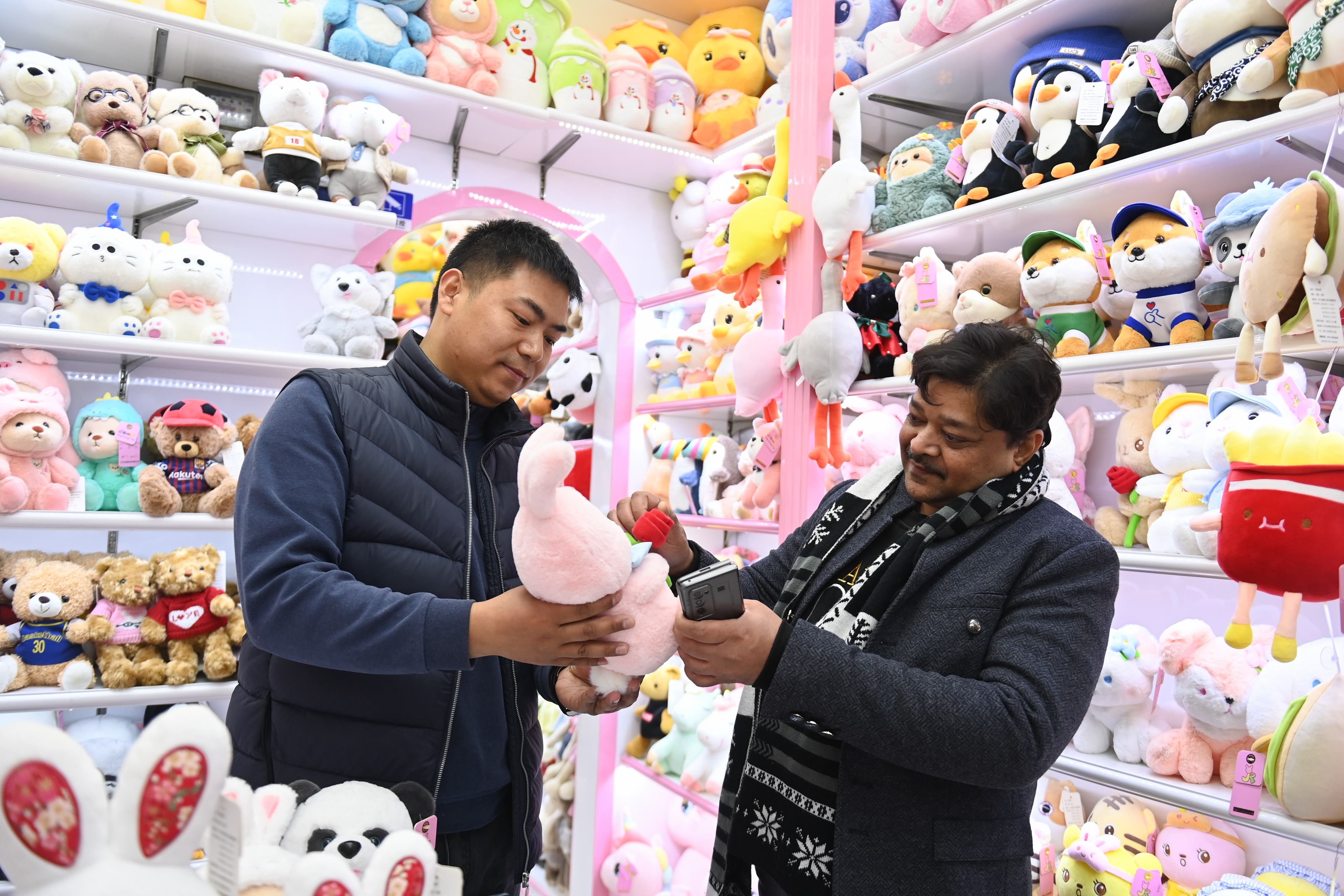 2023年2月2日，來(lái)自印度的客商（右）在義烏國(guó)際商貿(mào)城的一家玩具店鋪內(nèi)選購(gòu)。