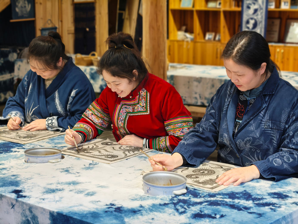 2025年3月14日，村民在肇興侗寨內(nèi)制作蠟染。圖片來(lái)源：新華社