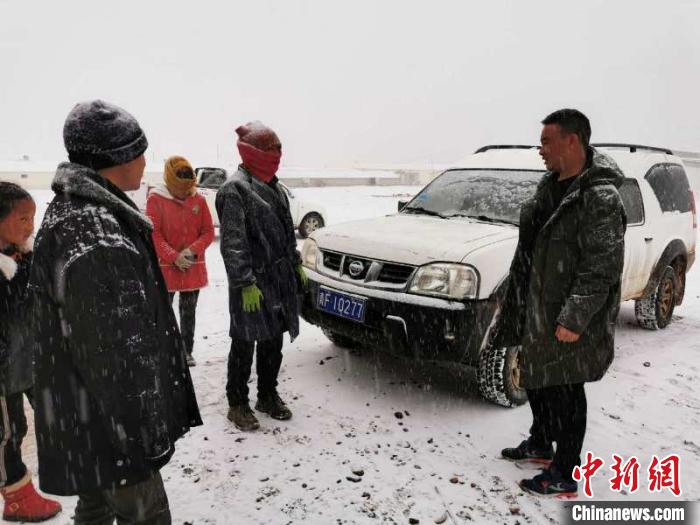 圖為扎西鬧吾(右一)與當(dāng)?shù)啬翍?hù)交談。郵儲(chǔ)銀行青海省分行供圖