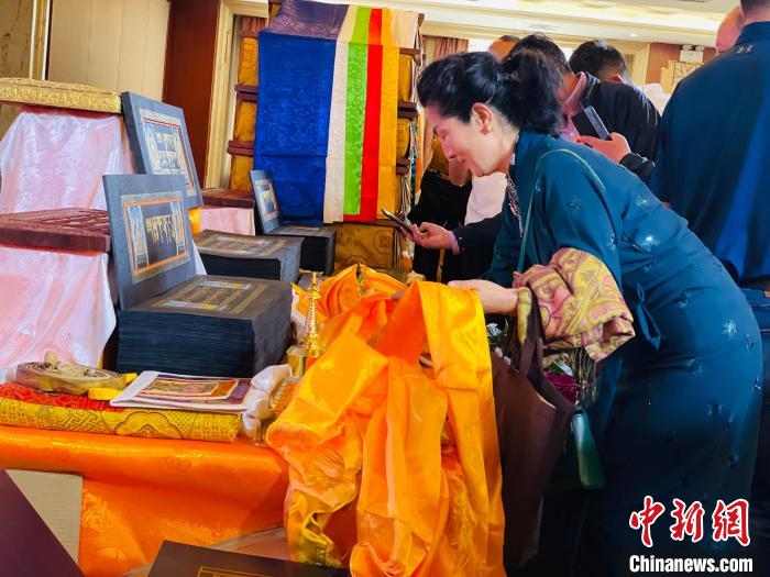 圖為現(xiàn)場(chǎng)藏族民眾向黃金書寫的大藏經(jīng)《甘珠爾》敬獻(xiàn)哈達(dá)?！O睿 攝