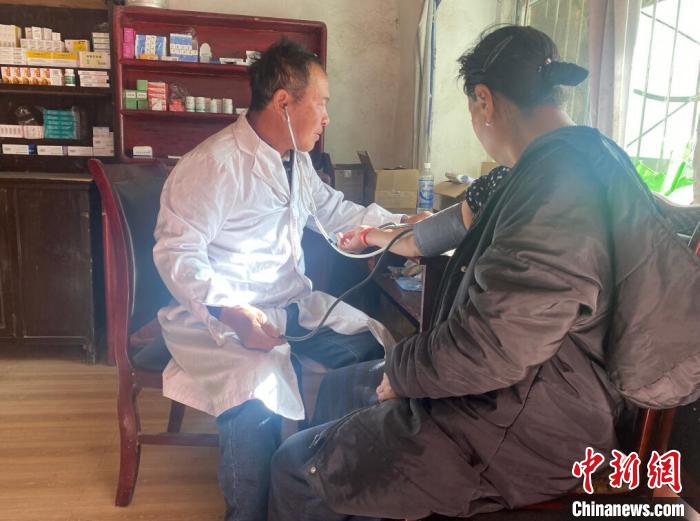 索木滾(左)為村民看病?！∪捞量h委宣傳部供圖