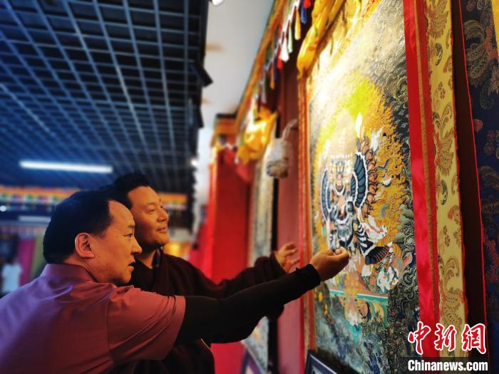 圖為久美尖措展示唐卡作品。　張?zhí)砀?攝