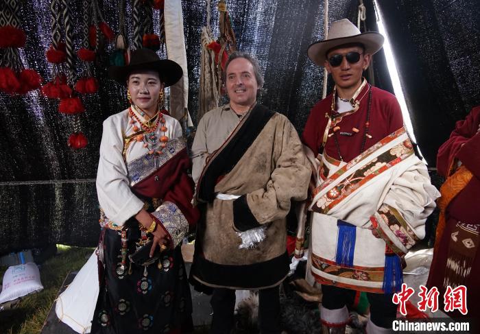 圖為一名外籍攝影師(中)身穿藏服和藏族民眾合影留念?！●R銘言 攝