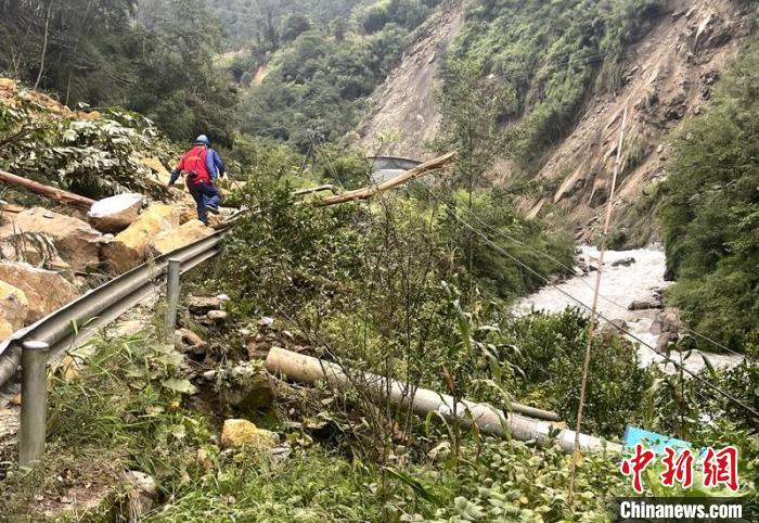 電力搶險人員快速通過危險路段，旁邊是受損的電力線路 四川電力供圖