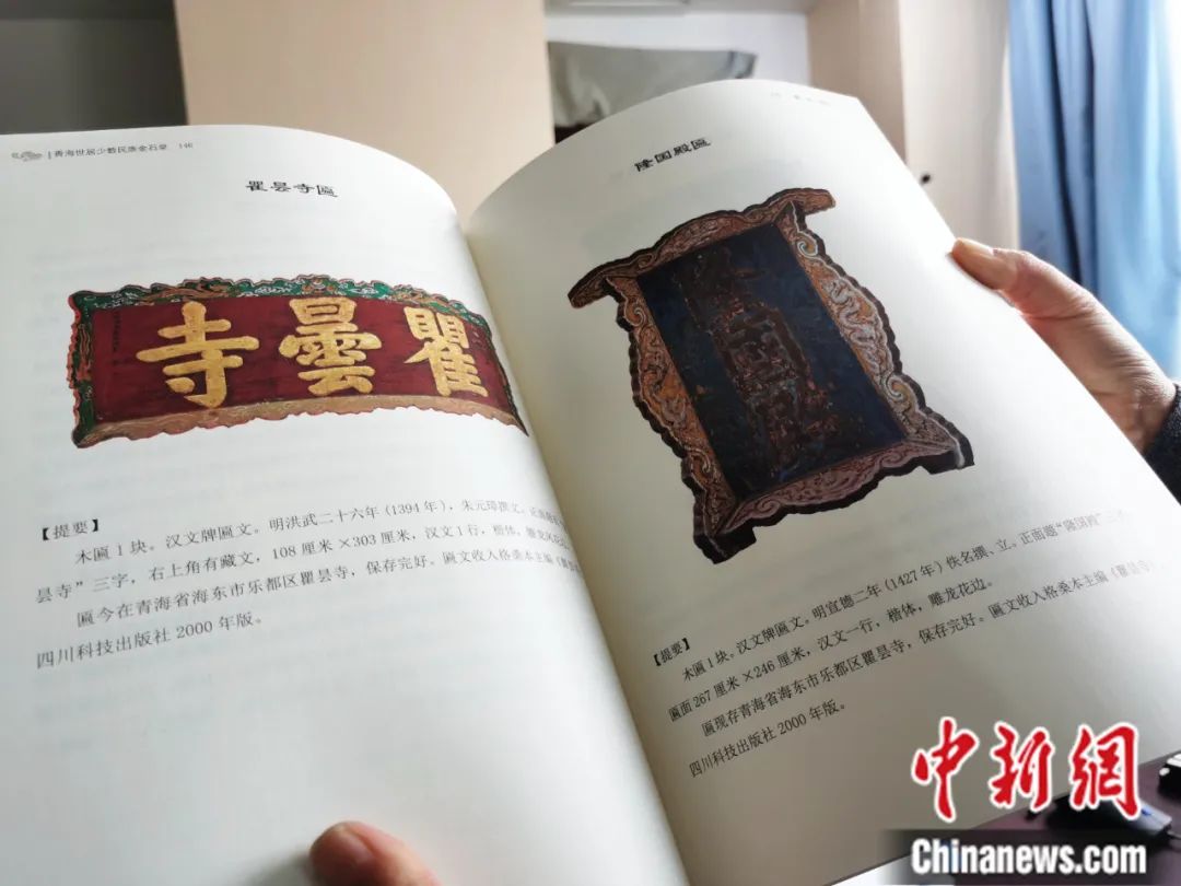 古籍保護(hù)人員展示介紹明代朱元璋撰寫的青海瞿曇寺匾(左)的出版書籍。張?zhí)砀?攝