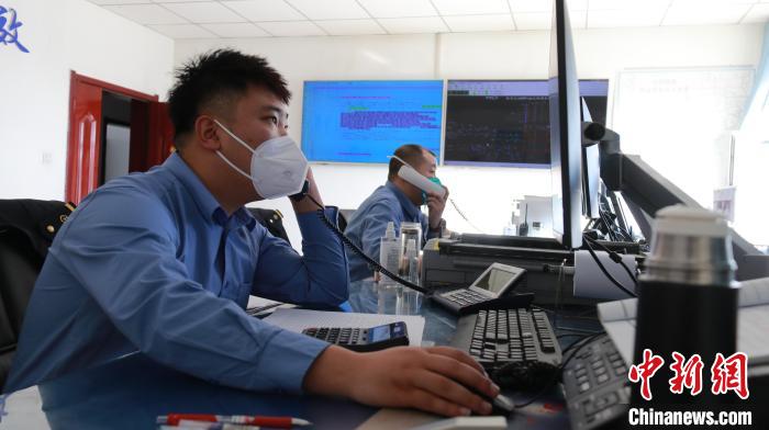 圖為貨運調(diào)度人員與外勤工作人員聯(lián)系掌握車輛裝載情況?！±钌?攝