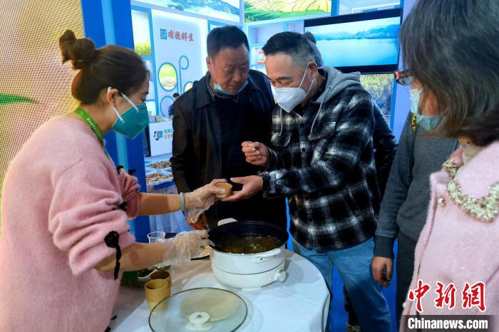 圖為杭州市民品嘗茶卡羊肉?！±铍h 攝