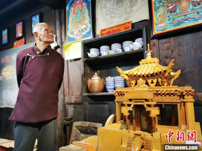 圖為古堡內(nèi)的藝人桑杰展示自己的雕刻作品?！?zhí)砀?攝