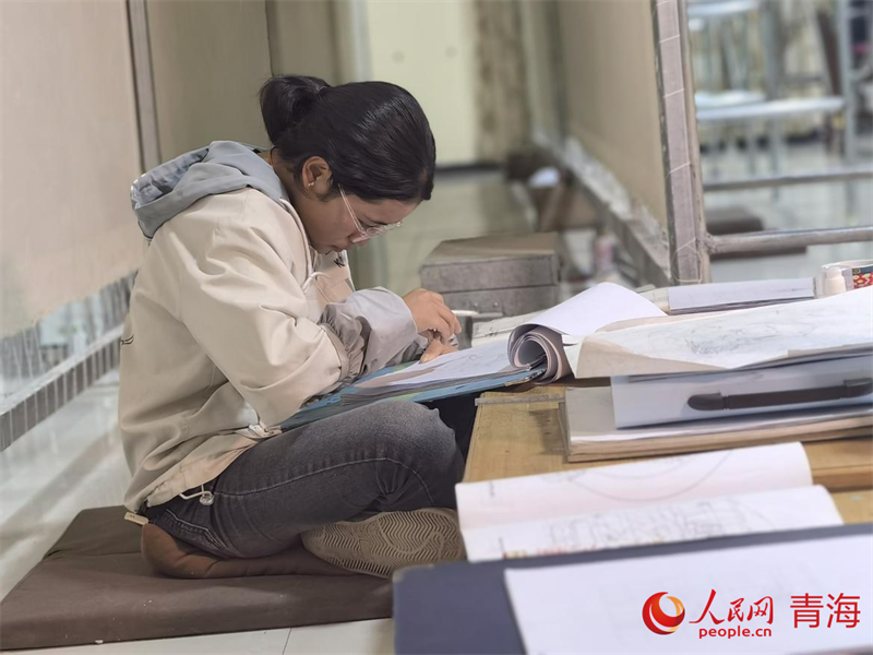 正在學(xué)習(xí)畫底稿的尕讓旺姆。人民網(wǎng) 陳明菊攝