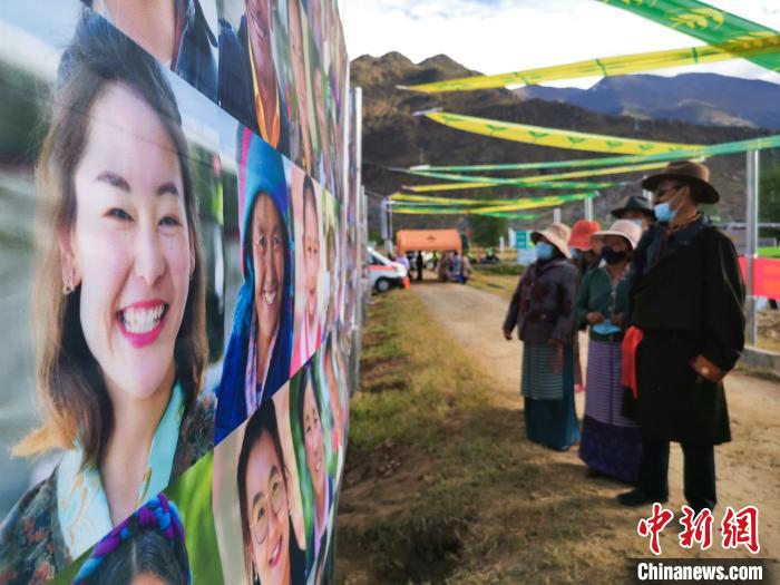 圖為當(dāng)?shù)孛癖娫谟^看展板上的笑臉。　張偉 攝