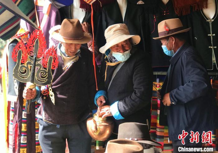 圖為三位藏族老人在集市上聊天交談。　冉文娟 攝