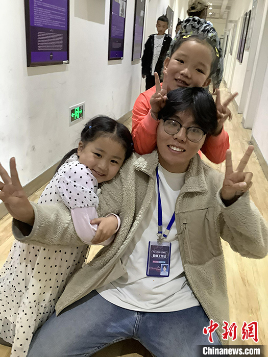 “Z世代”旦真旺加認為，拉薩是一座開放與包容的城市，記憶中的拉薩是彩色的。2021年，旦真旺加從浙江大學漢語言文學專業(yè)畢業(yè)后，他選擇回到拉薩，成為一名漢語文實習助教。圖為8月4日，旦真旺加在課間陪學生玩耍。 <a target='_blank' ><p  align=