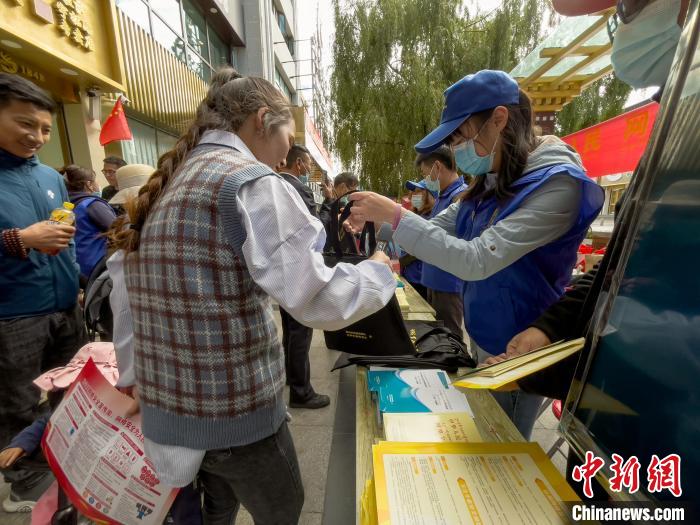 圖為志愿者為市民發(fā)放網(wǎng)絡(luò)安全宣傳手冊(cè)?！≈x牧 攝