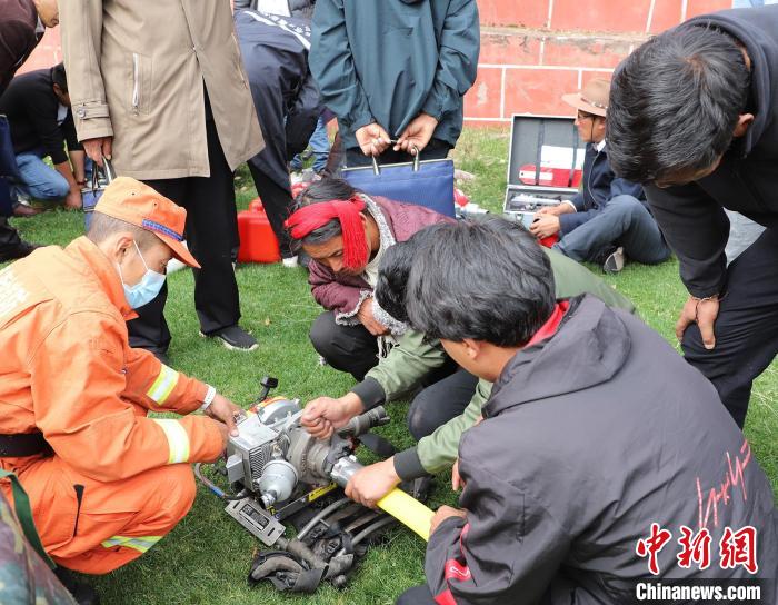 圖為森林消防員為護(hù)林員講解滅火裝備的使用方法。　昌都市森林消防支隊(duì) 供圖