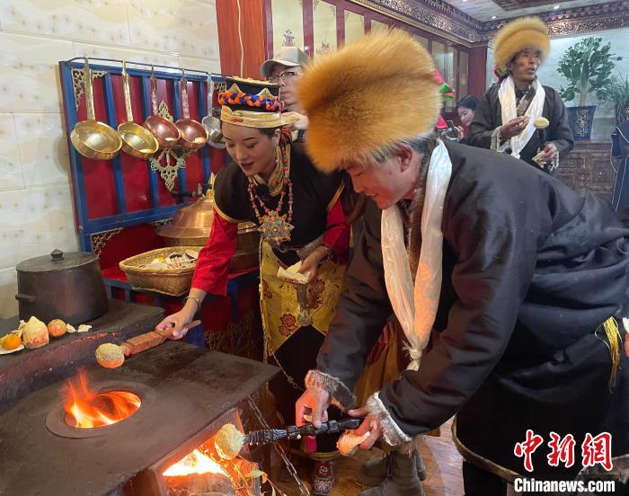 圖為人們?cè)诨鹕峡竟?jié)日美食“結(jié)達(dá)”?！∪轿木?攝
