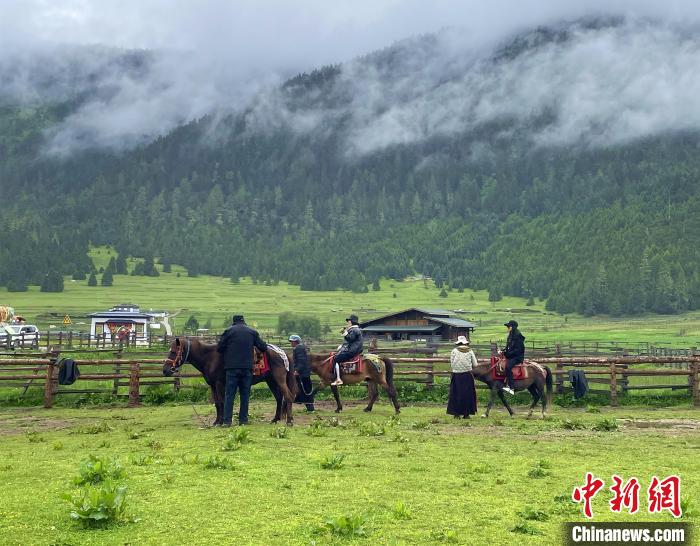 6月10日，游客在魯朗小鎮(zhèn)高山牧場(chǎng)景區(qū)體驗(yàn)騎馬?！∪轿木?攝