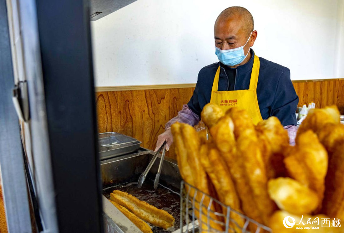 早餐店老板正在炸油條。人民網(wǎng) 次仁羅布攝