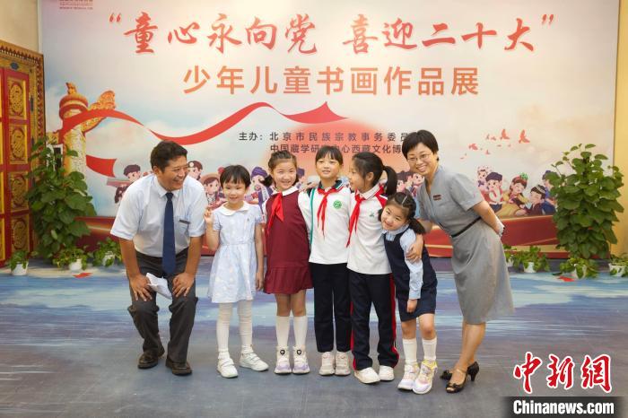 圖為與會(huì)嘉賓與入選畫(huà)作的“小作者”們?cè)谡褂[上合影?！≈袊?guó)藏學(xué)研究中心供圖