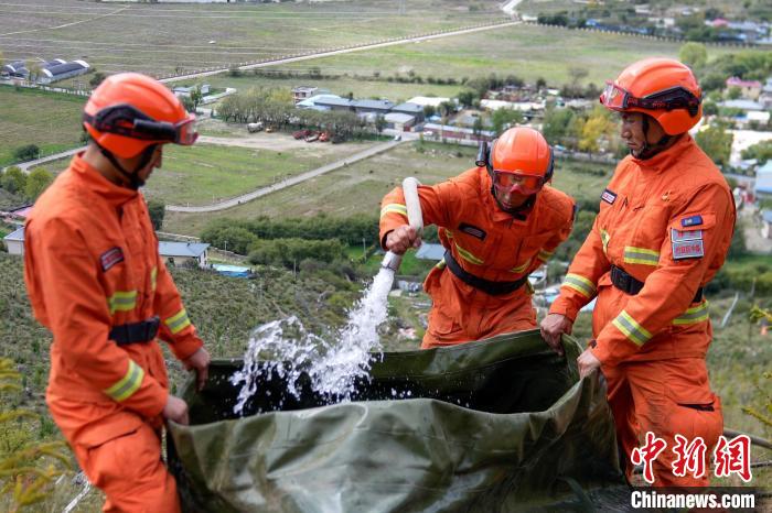 技能大練兵過(guò)程中，消防員在陡坡上向蓄水池注水?！±顕?guó)燾 攝