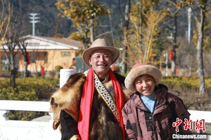 圖為林芝市巴宜區(qū)布久鄉(xiāng)仲果村村民桑杰與孫子一起參加藏歷新年活動(dòng)?！埩?攝