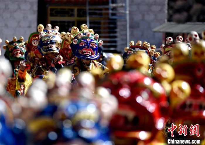 2月19日，楚布寺僧人們佩戴面具參加跳神活動(dòng)?！±盍?攝