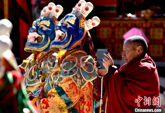 2月19日，正在拍攝跳神活動(dòng)的僧人?！±盍?攝
