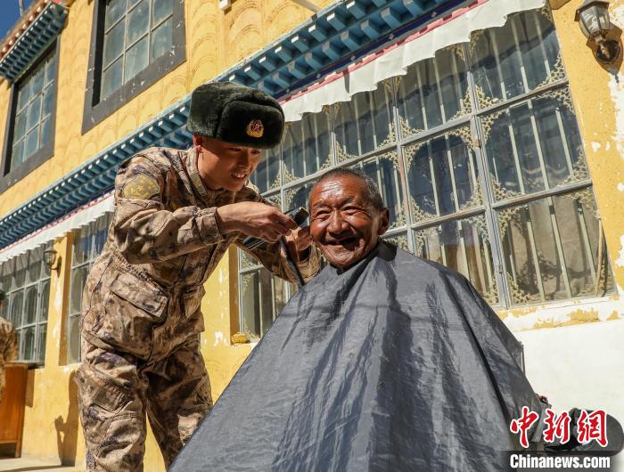 圖為阿里軍分區(qū)某邊防團(tuán)官兵為駐地群眾理發(fā)迎藏歷新年?！〉┰鰝愔?攝