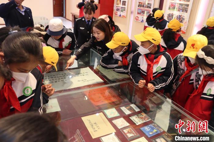 圖為亞東邊檢站民警為駐地小學(xué)生講解該站榮譽發(fā)展史。　胡利媛 攝