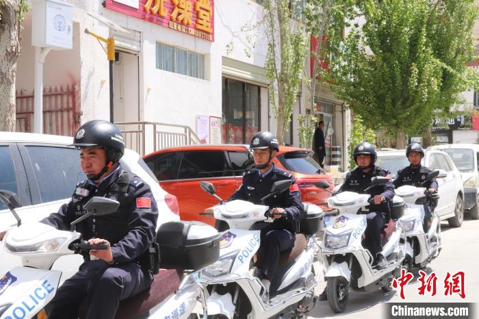 民警騎著電瓶車在轄區(qū)巡邏走訪。　黃創(chuàng)偉 攝