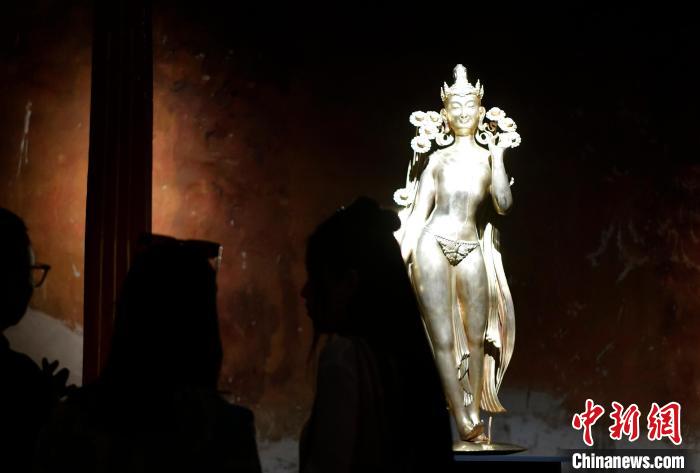 圖為觀眾正在欣賞展覽中的雕塑作品《八萬四千年》?！±盍?攝