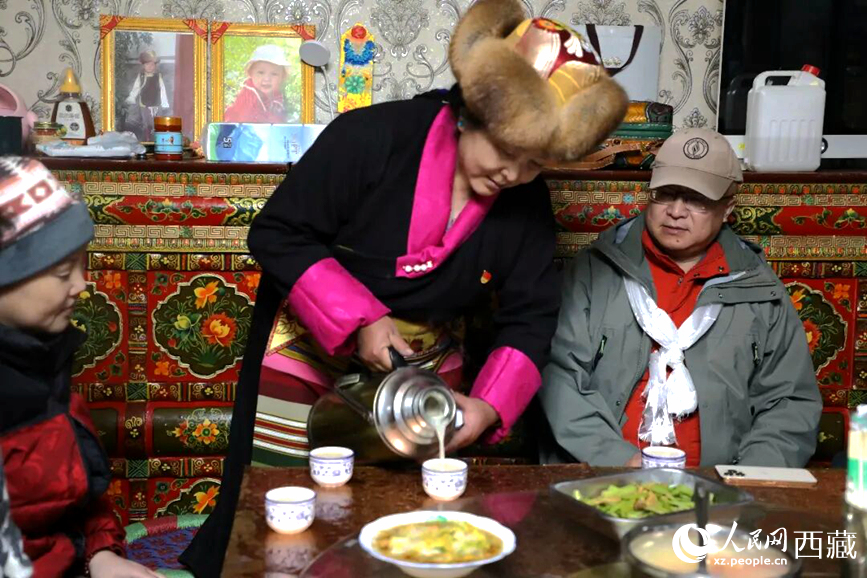 扎西曲登社區(qū)的居民在家中熱情招待遠(yuǎn)道而來的游客。居民身著盛裝，為游客倒上熱騰騰的酥油茶，桌上擺放著切瑪與特色美食，賓主共話民族團(tuán)結(jié)情誼。人民網(wǎng)記者 吳雨仁攝