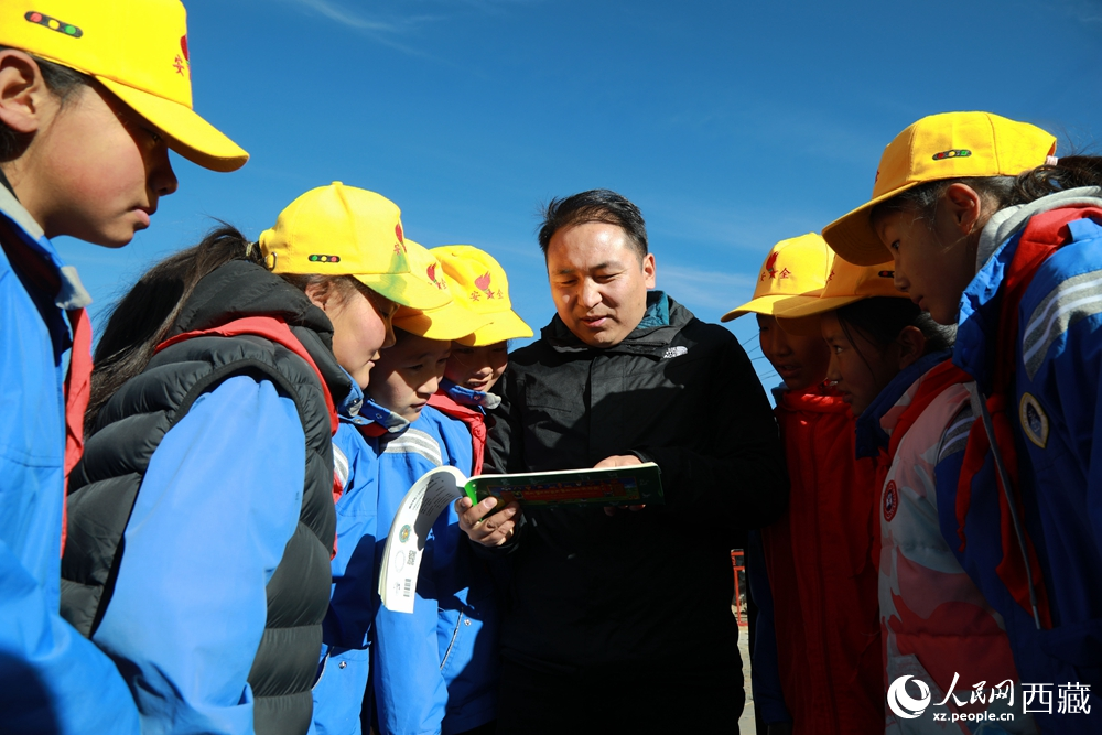 西藏自治區(qū)藏醫(yī)院專家為拉東村小學(xué)生講解天文歷算原理，孩子們圍站聆聽，感受傳統(tǒng)智慧與現(xiàn)代科普的融合。人民網(wǎng)記者 吳雨仁攝