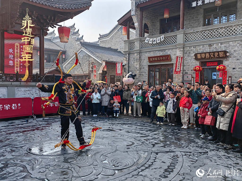 2025年1月29日，湖北襄陽(yáng)市管家巷，老北京天橋大刀張舉大刀拉硬弓第五代傳承人現(xiàn)場(chǎng)表演，一次拉開(kāi)6張弓，引來(lái)游客喝彩。人民網(wǎng)記者 郭婷婷攝