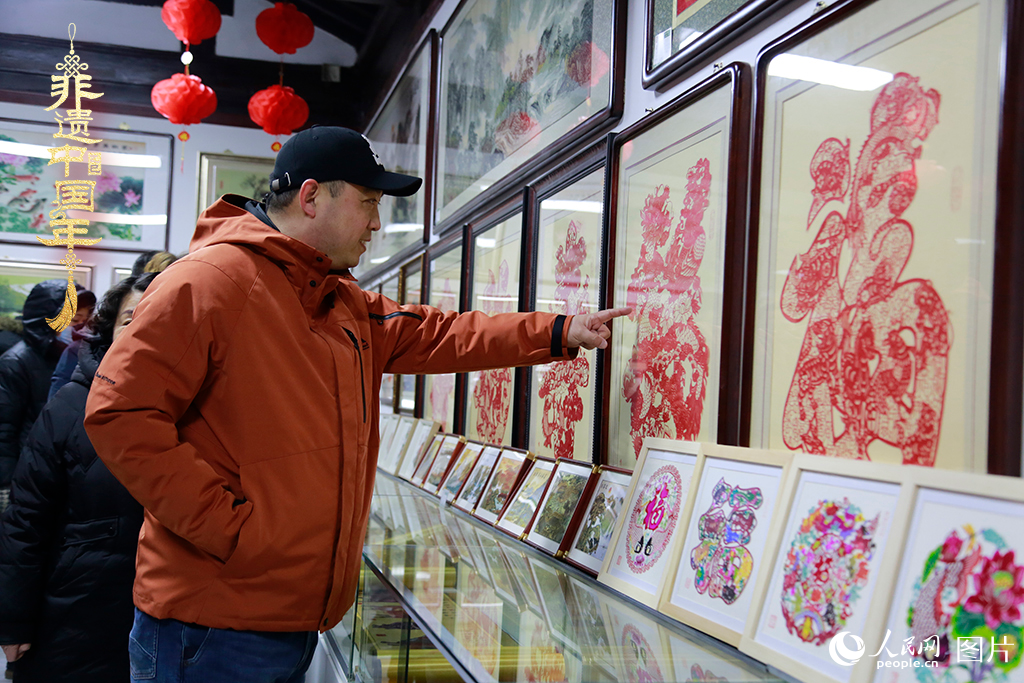 2025年1月23日，游客在天津楊柳青古鎮(zhèn)欣賞傳統(tǒng)剪紙作品，感受指尖上的古老藝術(shù)。人民網(wǎng)記者 崔新耀攝