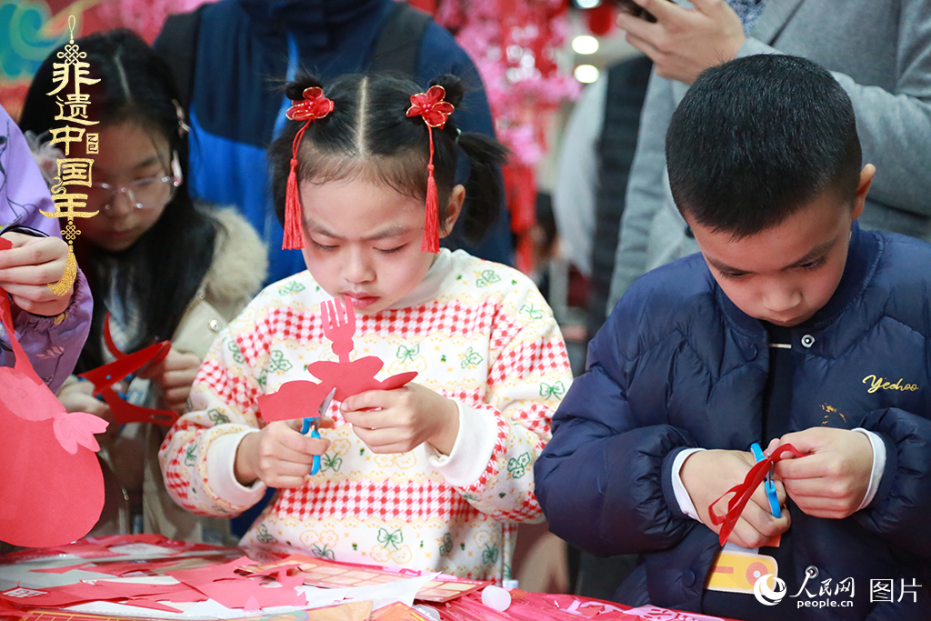2025年1月23日，上海市青少年活動(dòng)中心迎新春游園會(huì)上，小朋友們正在學(xué)習(xí)剪窗花。人民網(wǎng)記者 龔莎攝
