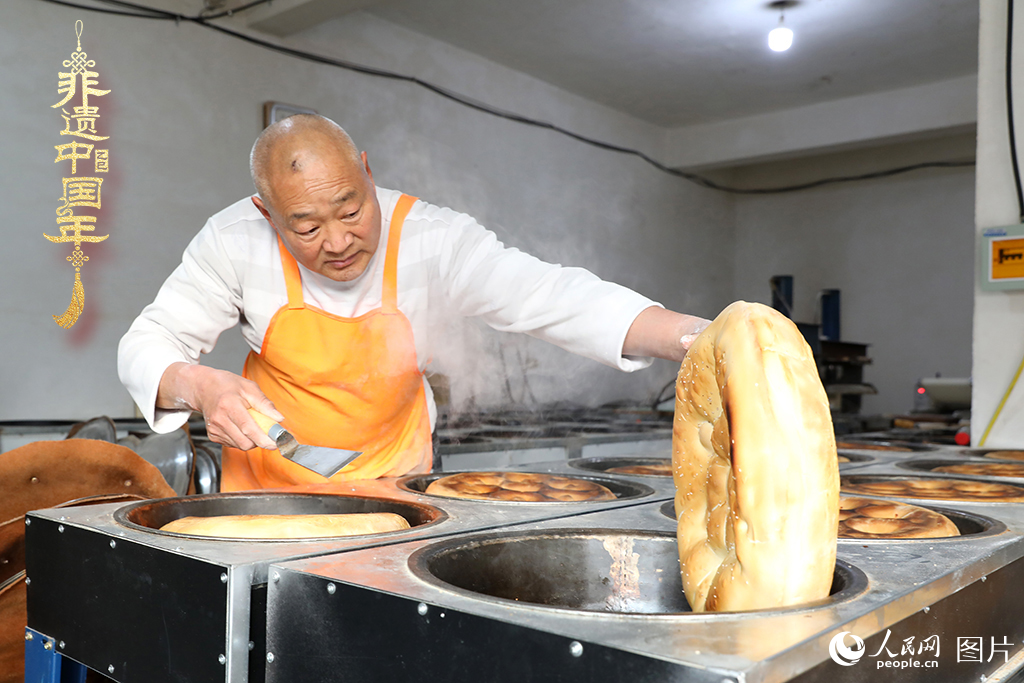 2025年1月23日，山東省臨沂市莒南縣一家傳統(tǒng)大餅作坊內(nèi)，師傅們正忙著烤制當(dāng)?shù)厝舜汗?jié)期間家家戶(hù)戶(hù)必備的、金黃誘人的莒南大餅。人民網(wǎng)記者 劉祺攝