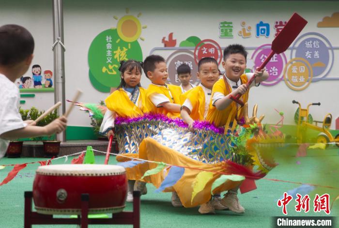 圖為龍舟賽游戲上，小伙伴們打鼓加油?！《^生 攝